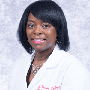 Picture of Dr. Lashawn Lee-Weaver, Brown-skinned female doctor with white doctor's coat with tite on jacket including OB-GYN